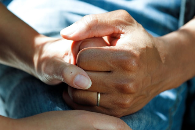 Two people holding hands in a gesture of support and care, BURG+CO. Marketing